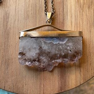 Long, amethyst, gold colored necklace.